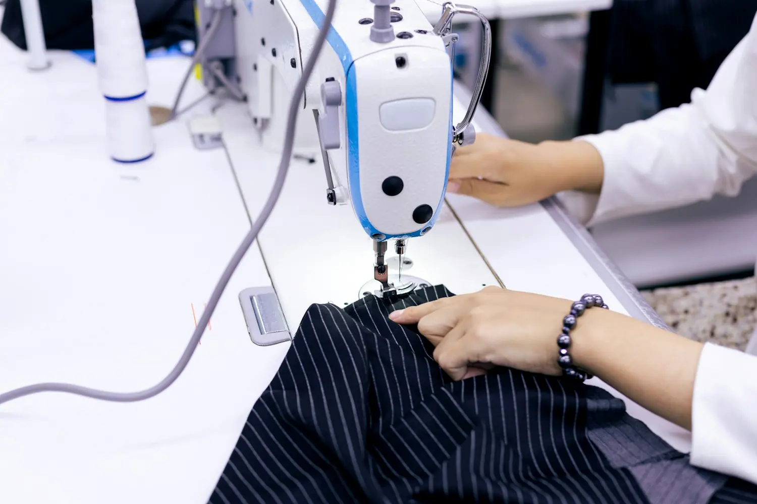 A tailor sewing striped cloth