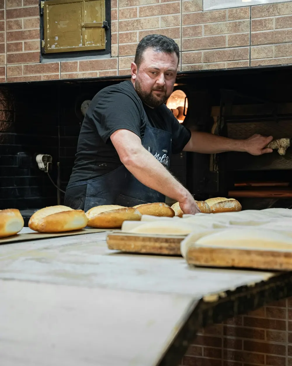 A baker at a wood-fired oven