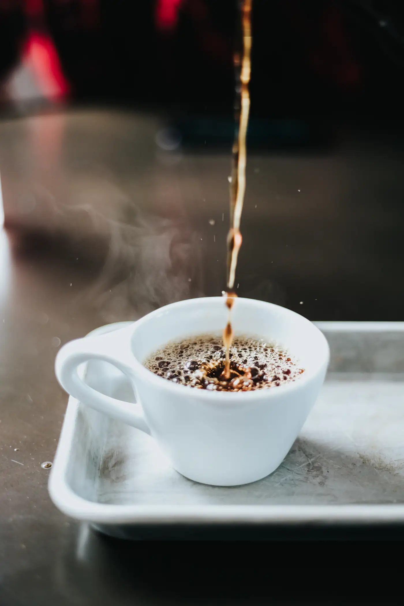 Coffee splashing into a white cup