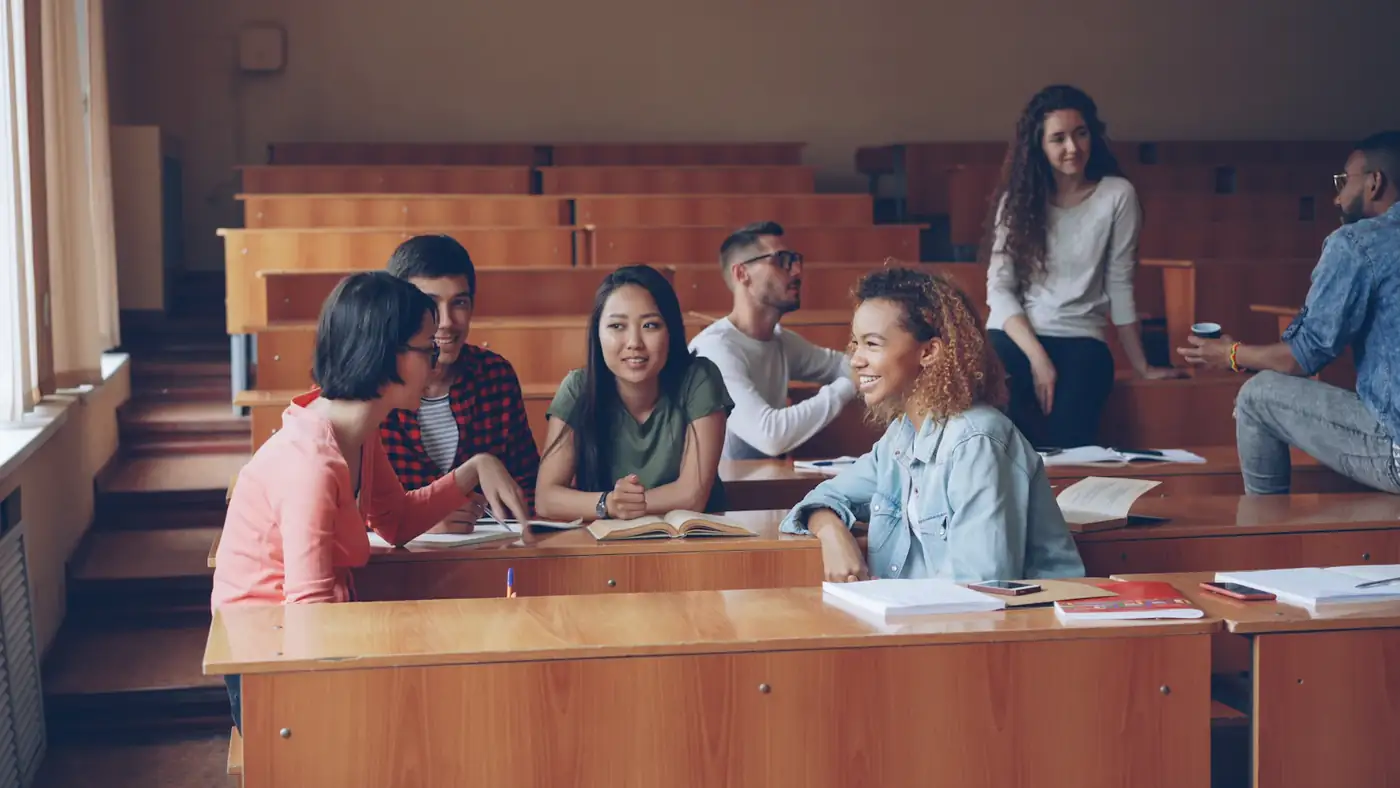 Older students laughing together at their desks