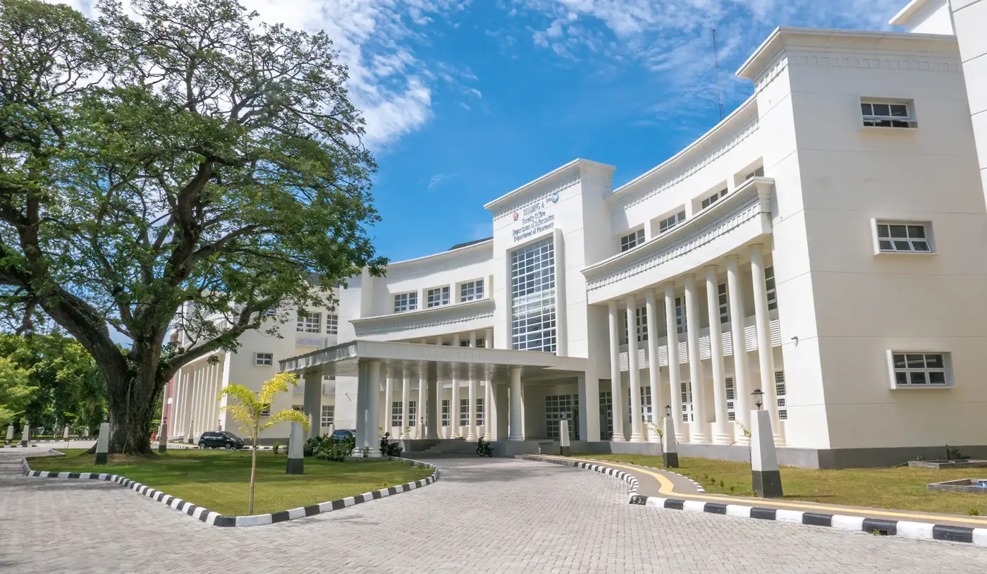 White campus building with columns under a blue sky