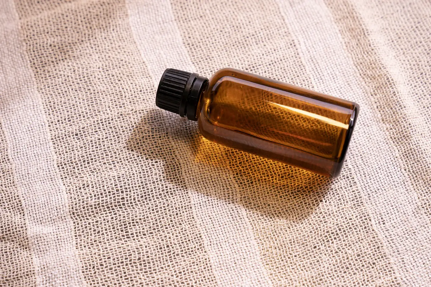 Amber bottle lying on linen