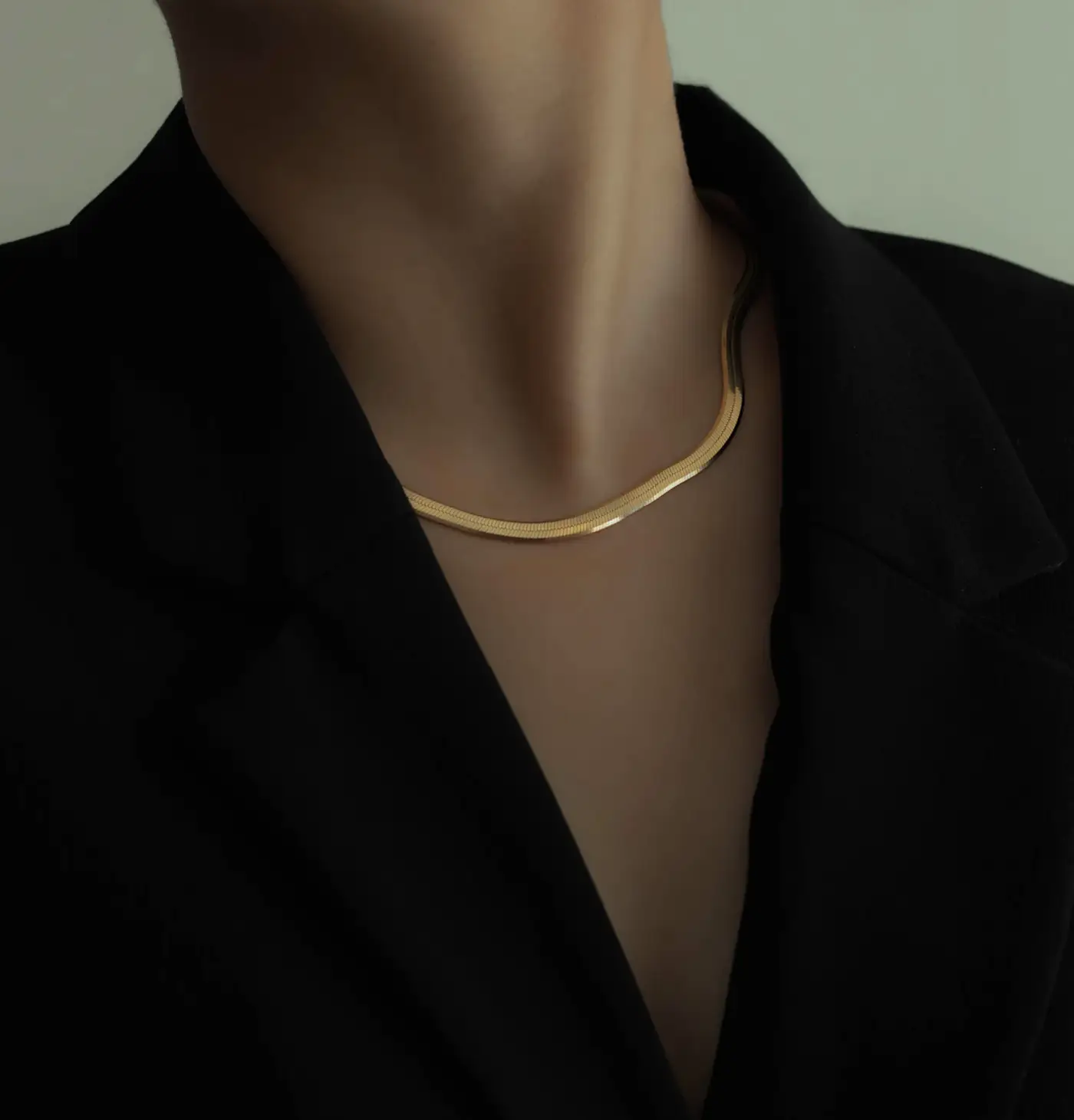 Gold snake chain worn over black clothing