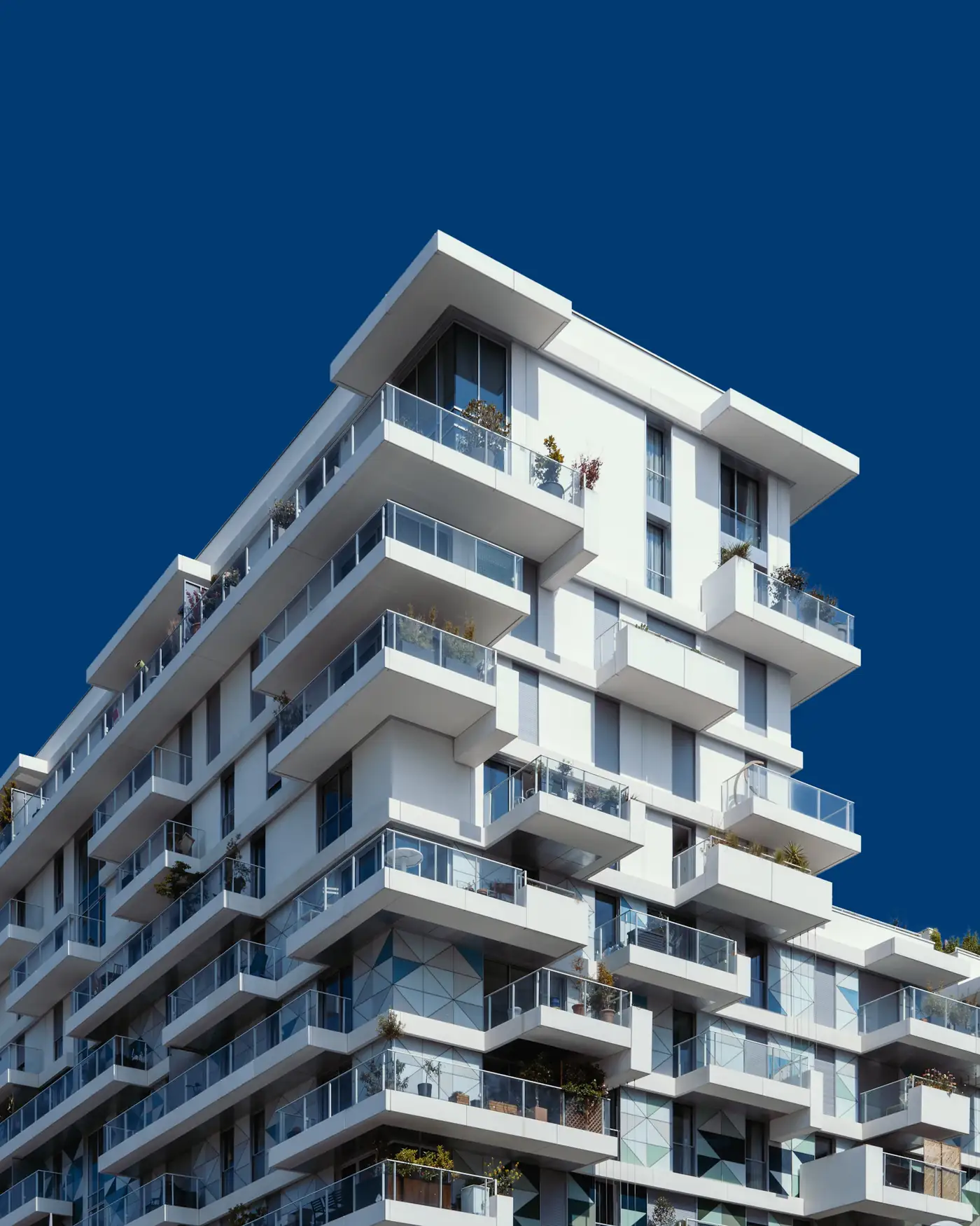 White stepped apartment block against a deep blue sky