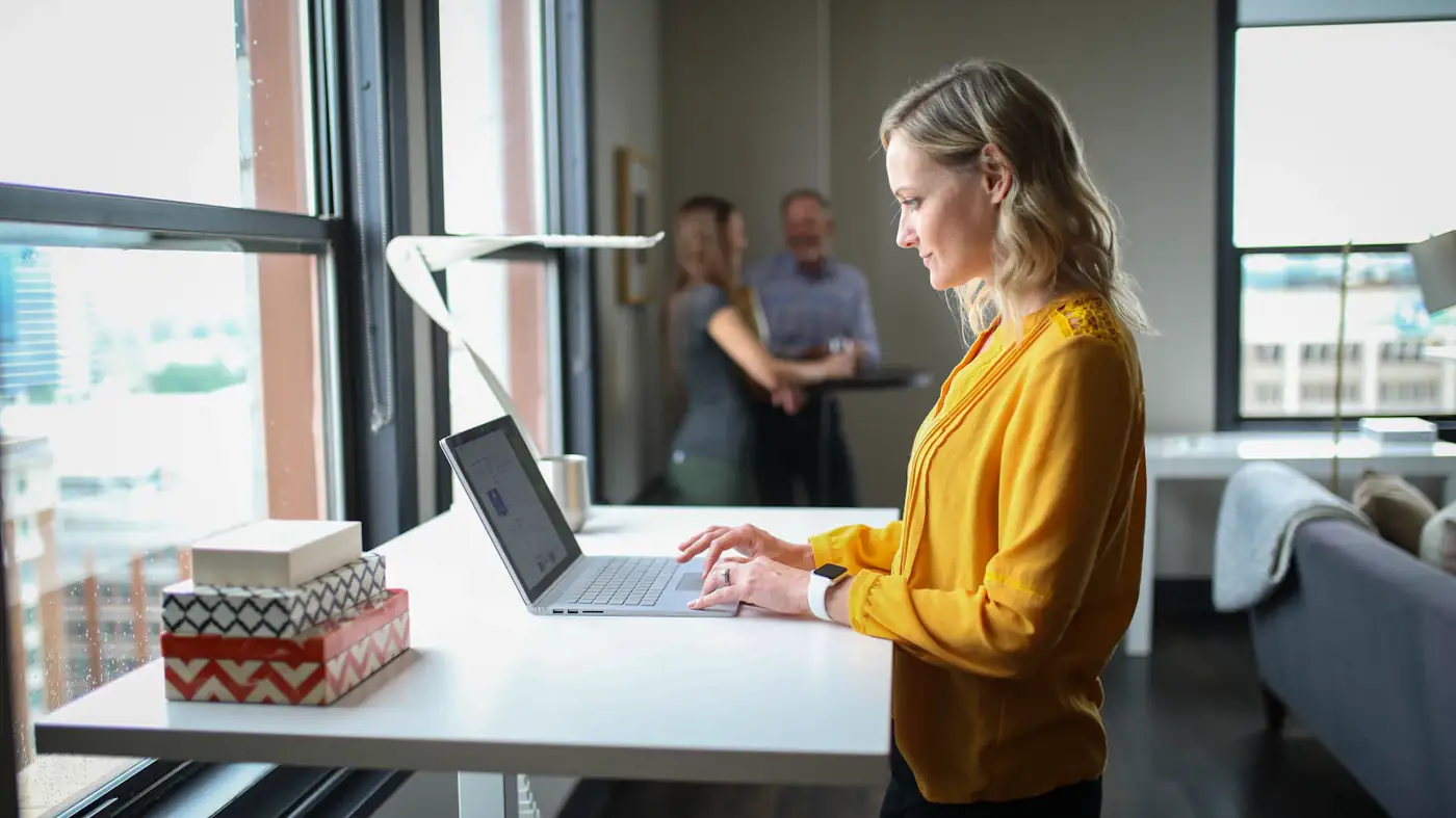 Woman in yellow working at a standing desk