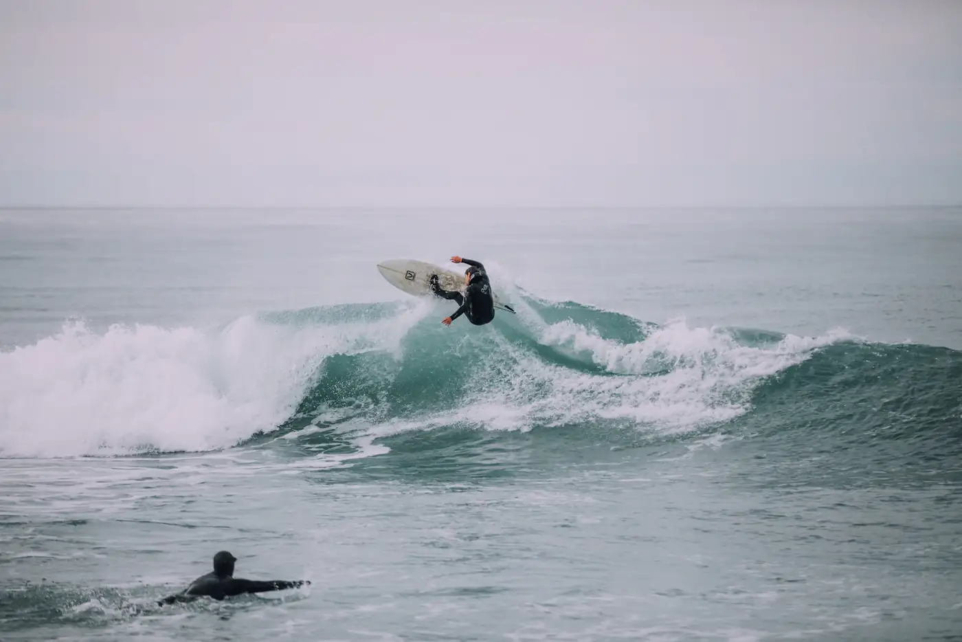 Surfer launching into the air off a wave