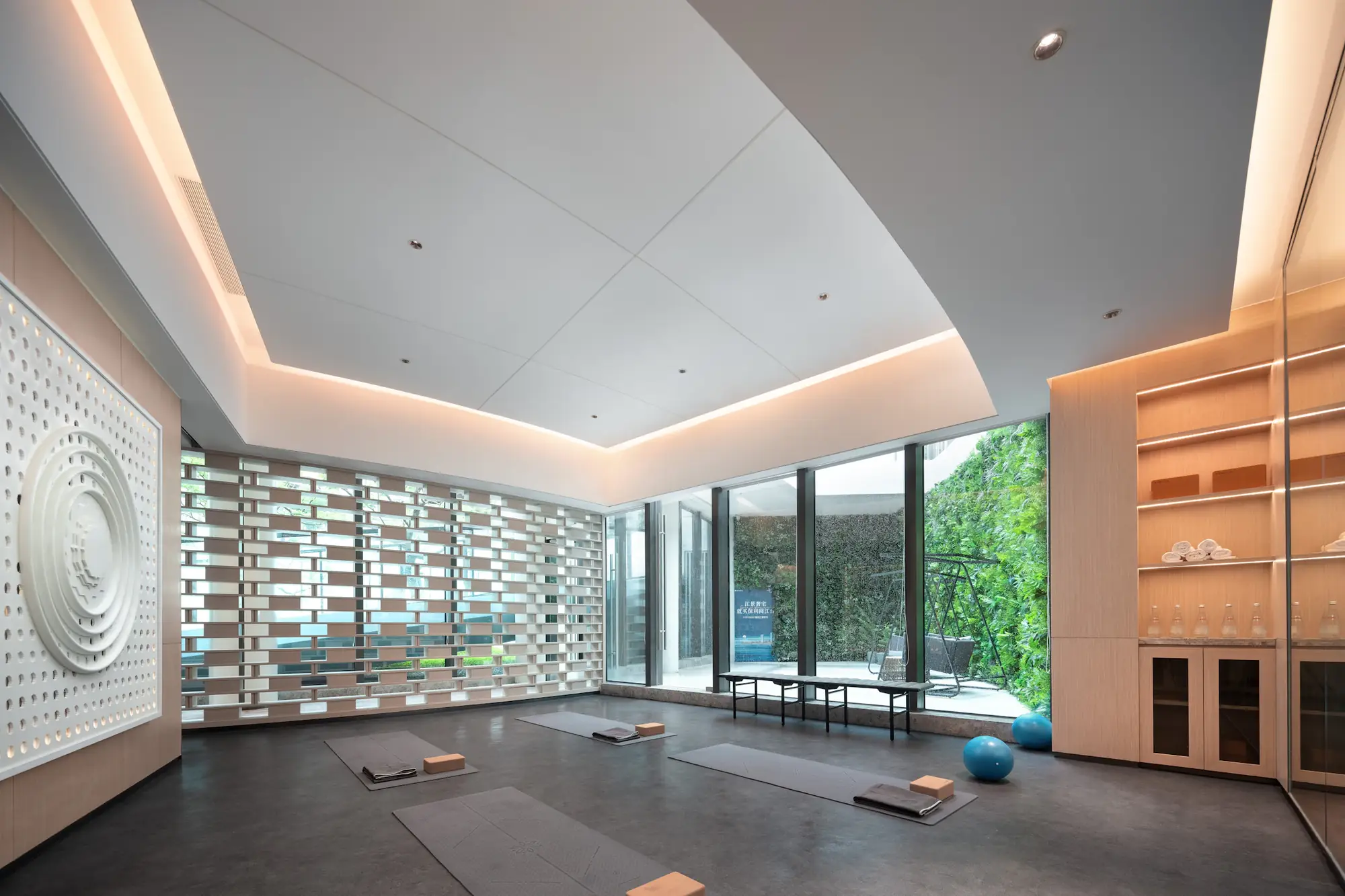 Bright studio with a curved ceiling, mats on the floor and a glass wall