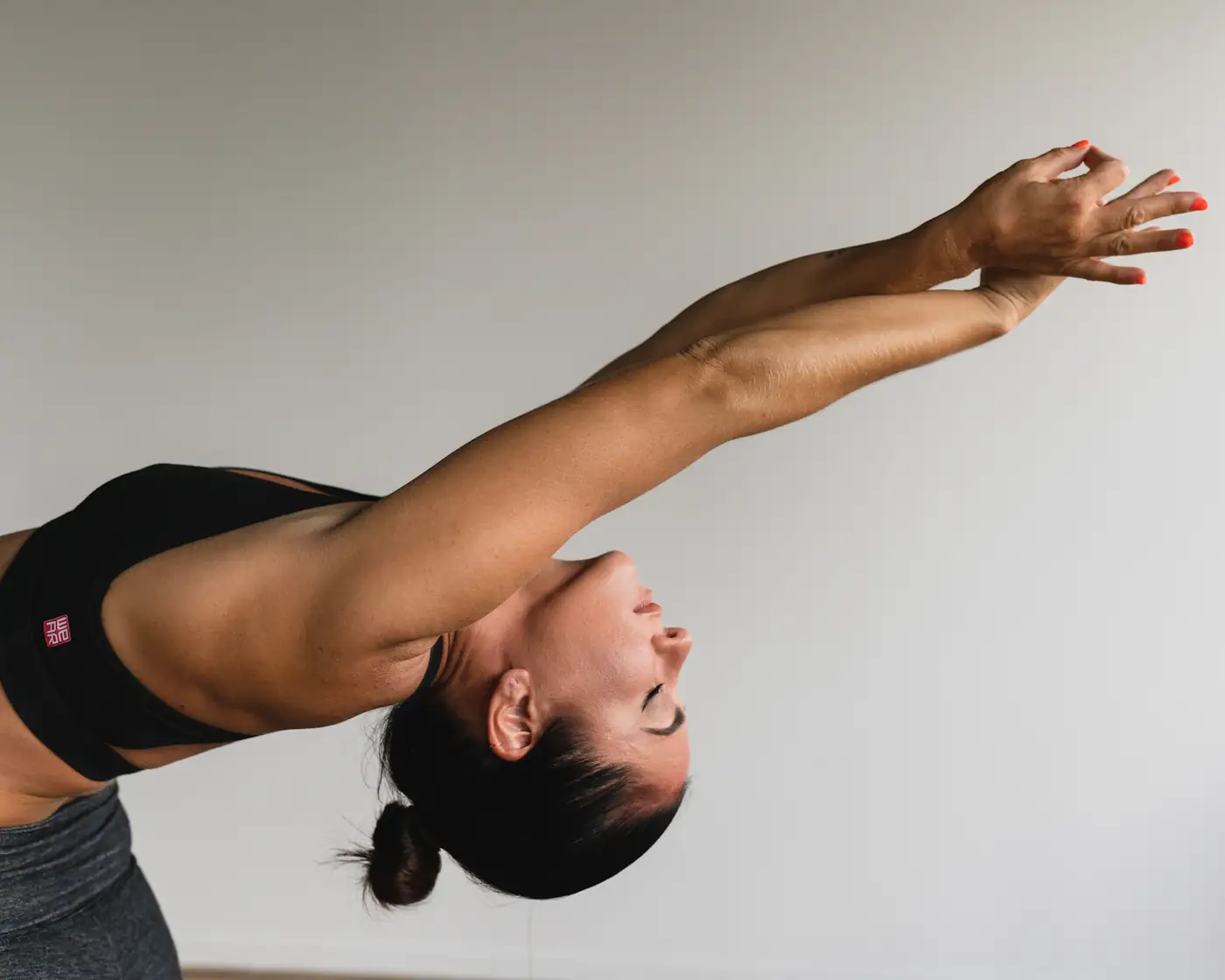 Woman stretching against a white wall