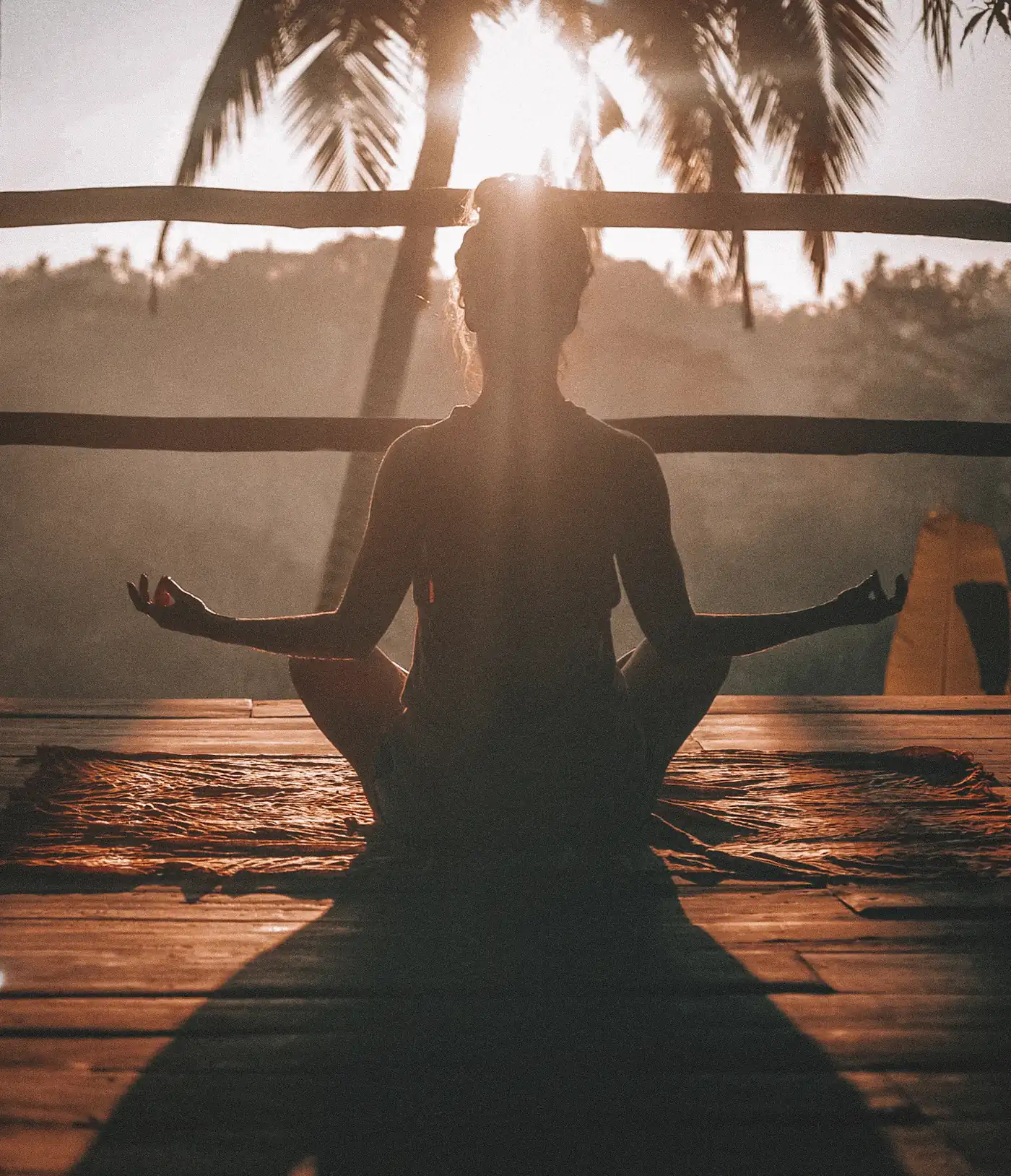 Silhouette meditating at sunset