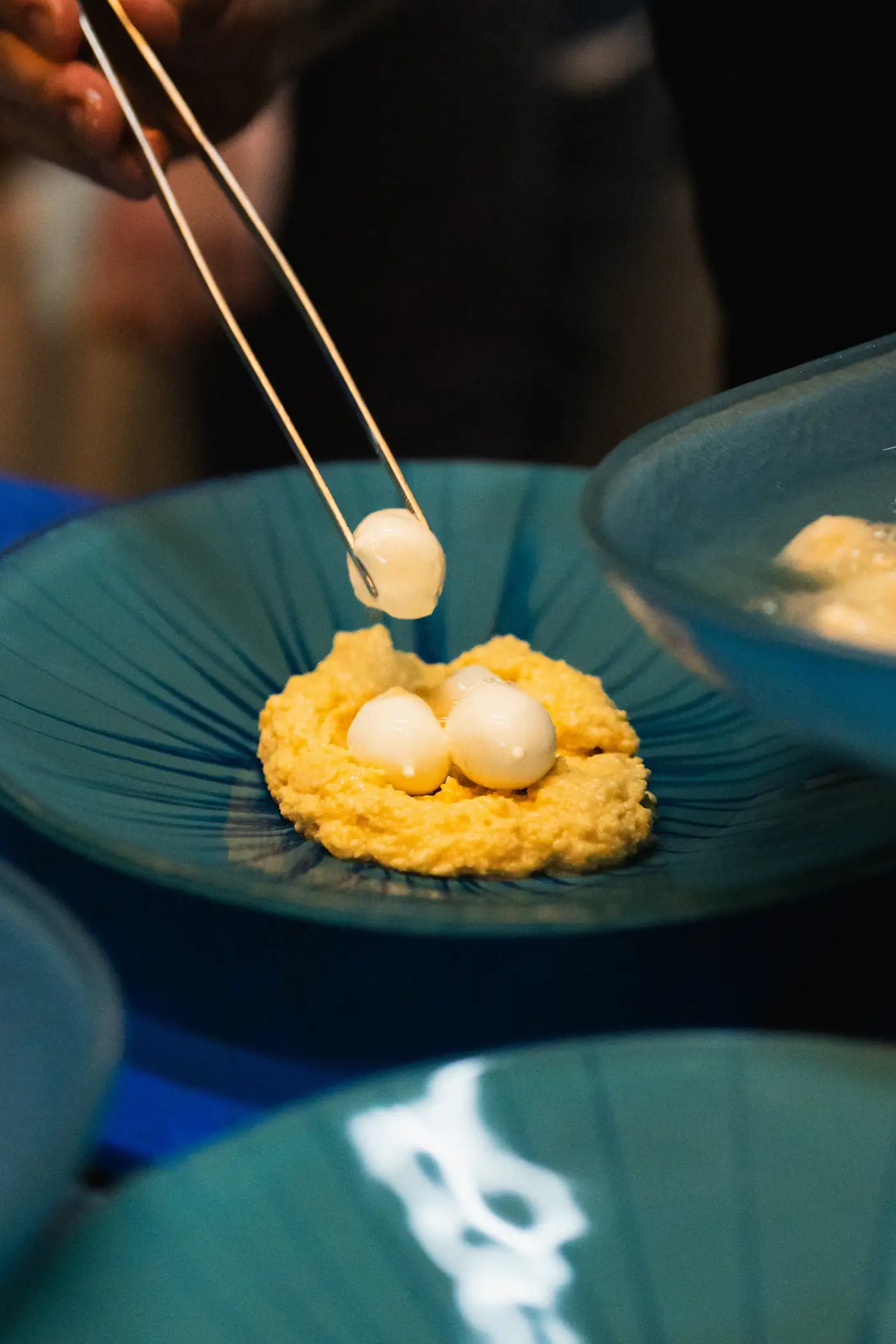 Quail eggs placed into a teal bowl