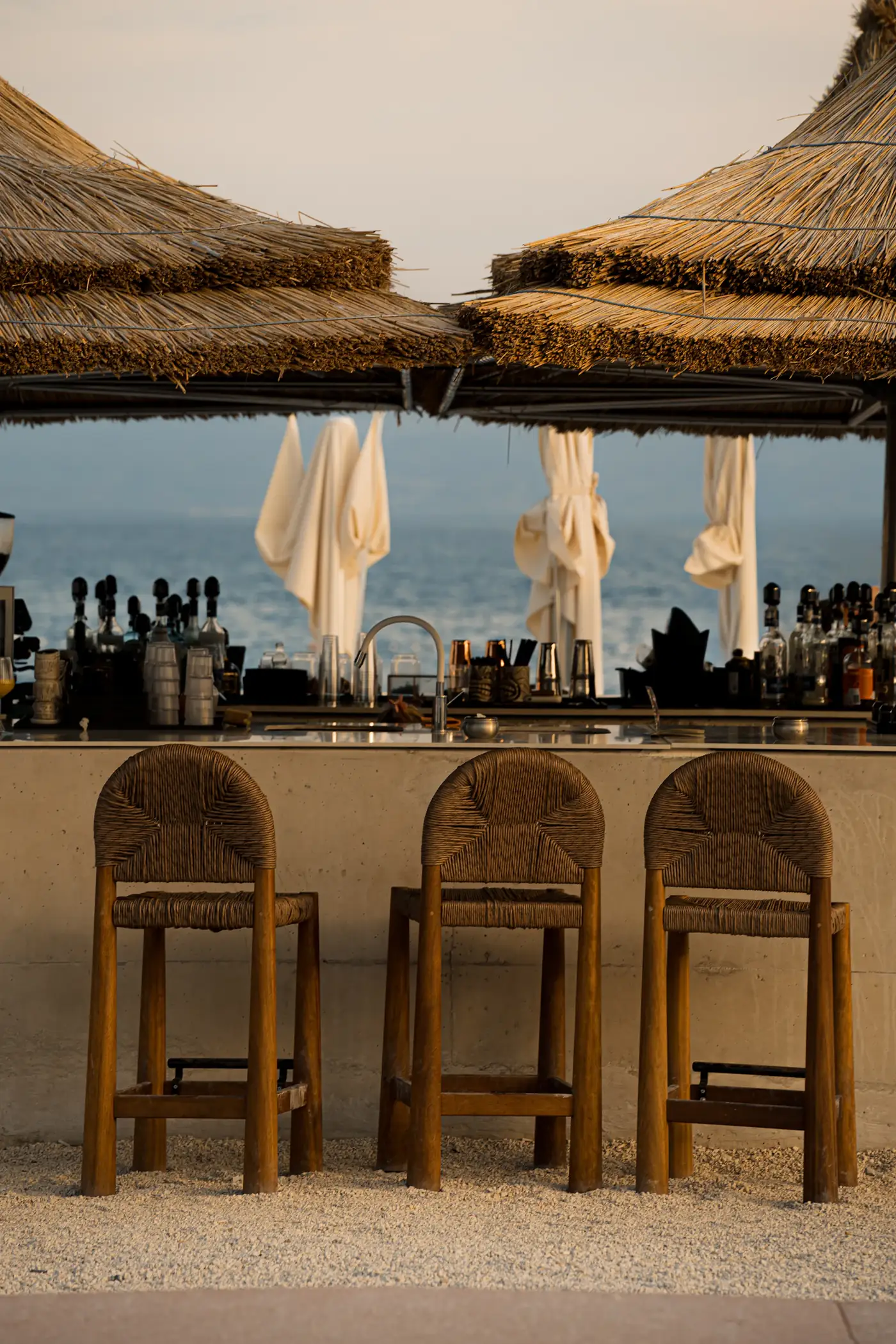 Thatched beach bar with rattan stools