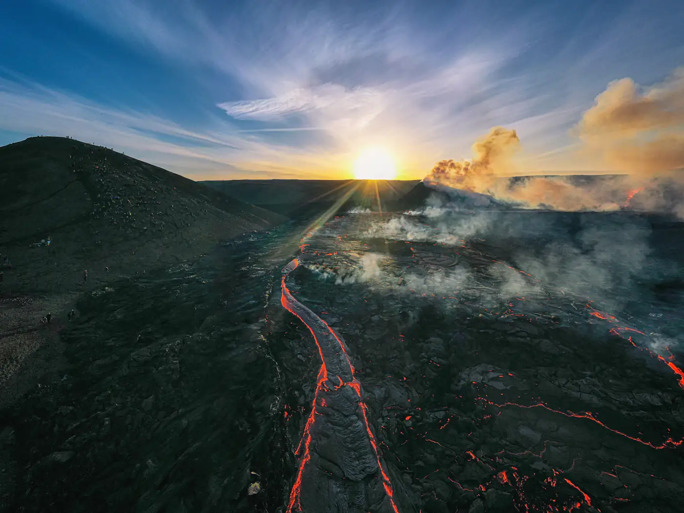 Lava glowing as it flows down a volcano at dawn